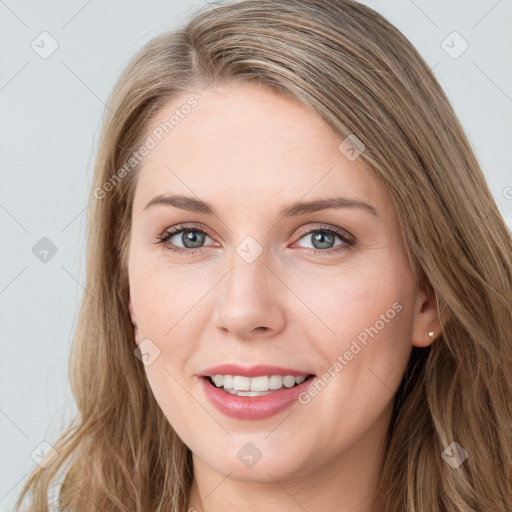 Joyful white young-adult female with long  brown hair and blue eyes