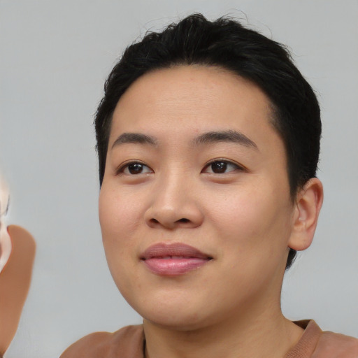 Joyful asian young-adult female with short  black hair and brown eyes