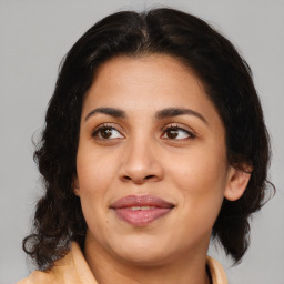 Joyful latino adult female with medium  brown hair and brown eyes