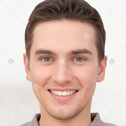 Joyful white young-adult male with short  brown hair and grey eyes