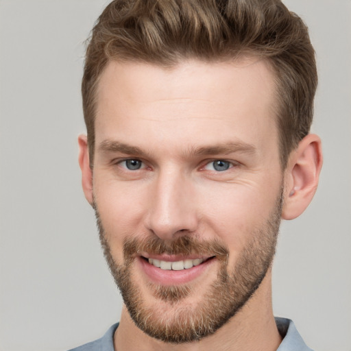 Joyful white young-adult male with short  brown hair and grey eyes