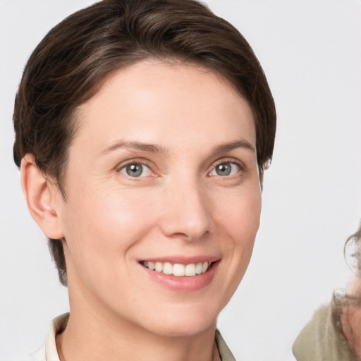 Joyful white young-adult female with medium  brown hair and grey eyes