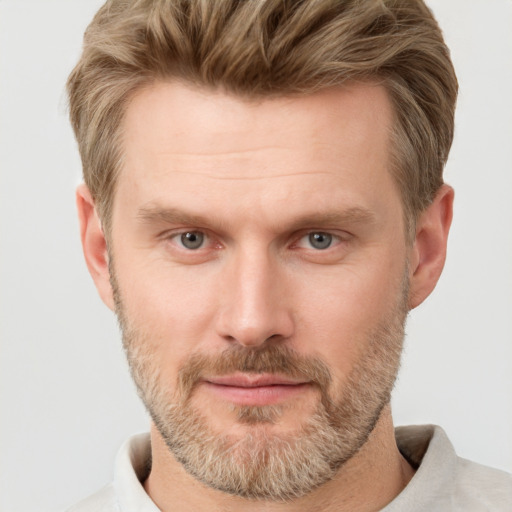 Joyful white adult male with short  brown hair and grey eyes