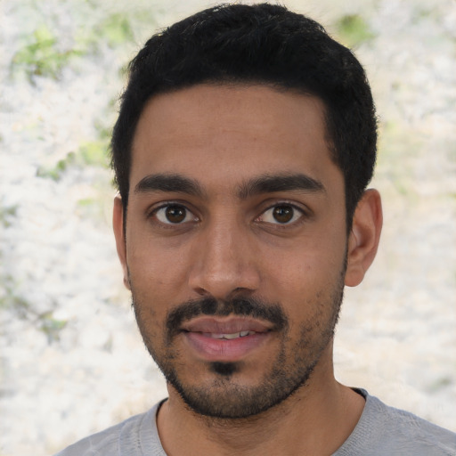 Joyful latino young-adult male with short  black hair and brown eyes