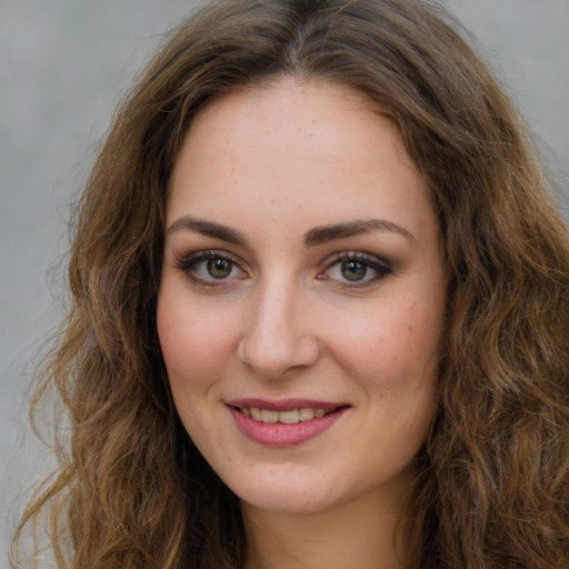 Joyful white young-adult female with long  brown hair and green eyes