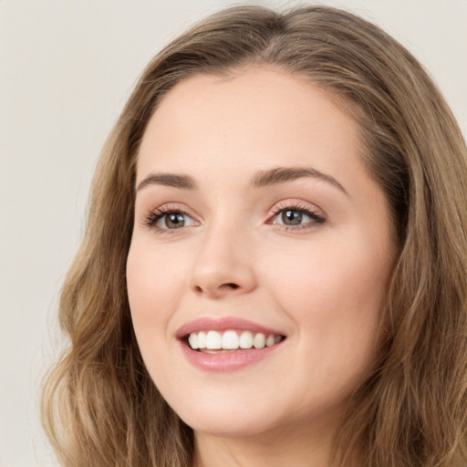 Joyful white young-adult female with long  brown hair and green eyes