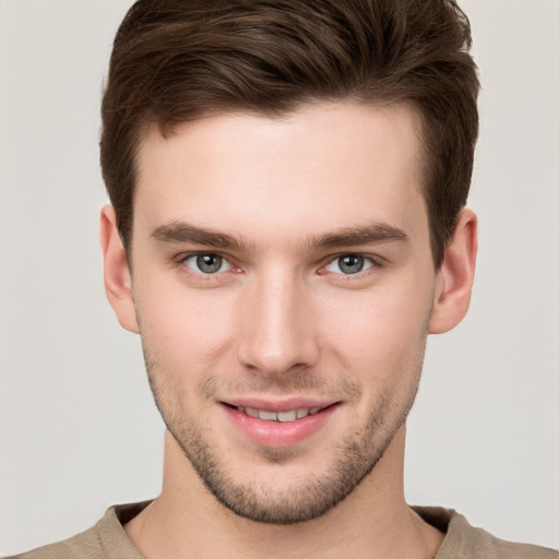 Joyful white young-adult male with short  brown hair and grey eyes