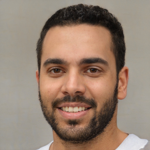 Joyful white young-adult male with short  black hair and brown eyes