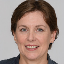 Joyful white adult female with medium  brown hair and grey eyes