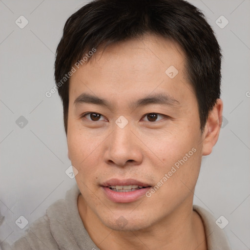 Joyful asian young-adult male with short  brown hair and brown eyes