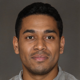 Joyful latino young-adult male with short  brown hair and brown eyes