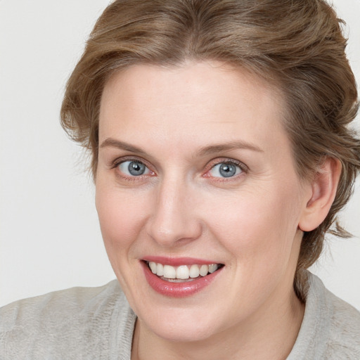 Joyful white young-adult female with medium  brown hair and blue eyes