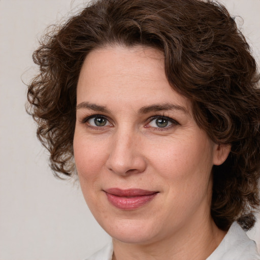 Joyful white adult female with medium  brown hair and green eyes