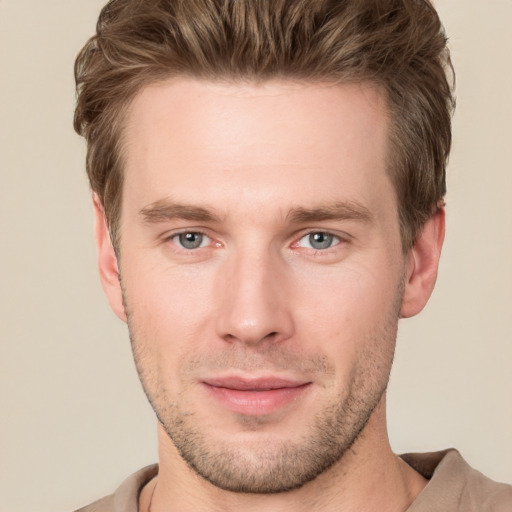 Joyful white young-adult male with short  brown hair and grey eyes