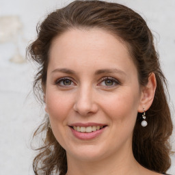 Joyful white young-adult female with long  brown hair and grey eyes