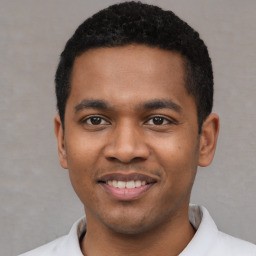 Joyful latino young-adult male with short  black hair and brown eyes