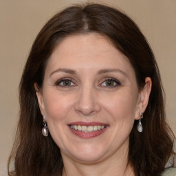 Joyful white adult female with long  brown hair and grey eyes