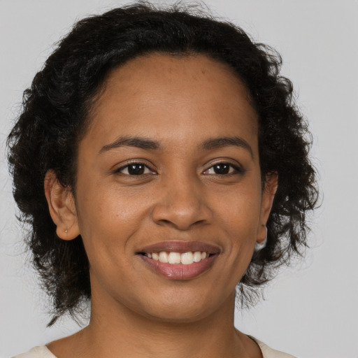 Joyful black young-adult female with medium  brown hair and brown eyes