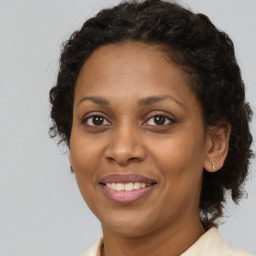 Joyful black adult female with long  brown hair and brown eyes