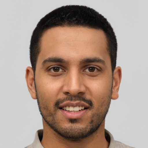 Joyful latino young-adult male with short  brown hair and brown eyes