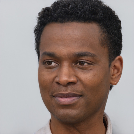 Joyful black young-adult male with short  black hair and brown eyes