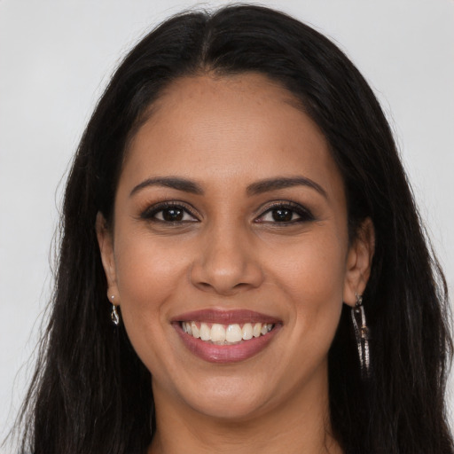 Joyful latino young-adult female with long  brown hair and brown eyes