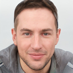 Joyful white young-adult male with short  brown hair and grey eyes