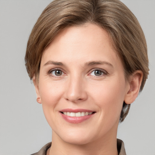 Joyful white young-adult female with medium  brown hair and grey eyes