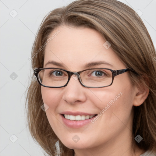 Joyful white young-adult female with long  brown hair and grey eyes