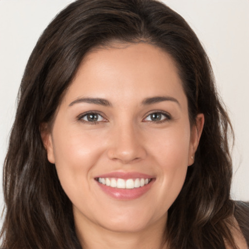 Joyful white young-adult female with long  brown hair and brown eyes