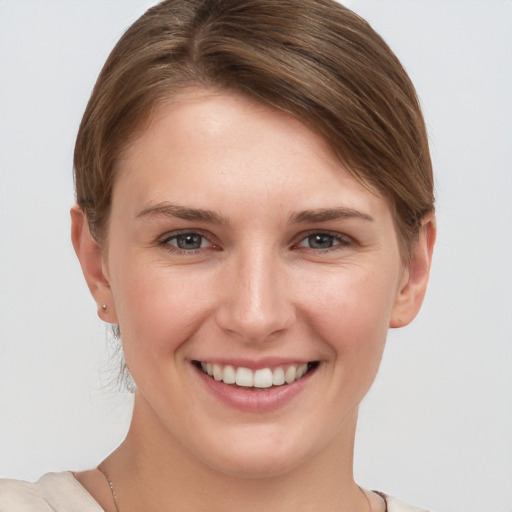 Joyful white young-adult female with short  brown hair and grey eyes