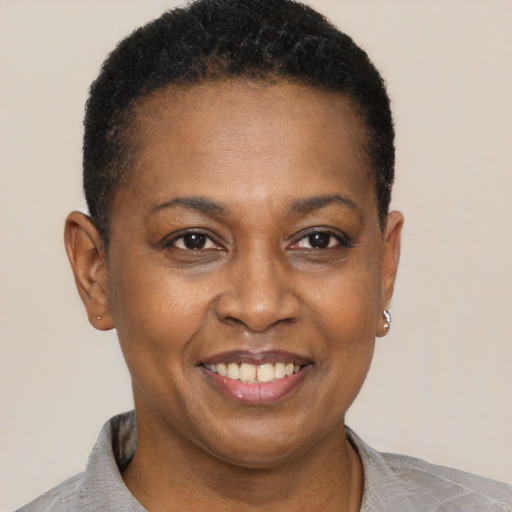 Joyful black adult female with short  black hair and brown eyes