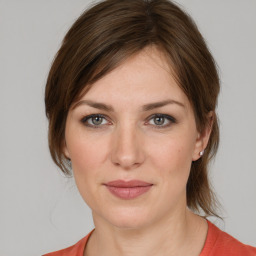 Joyful white young-adult female with medium  brown hair and grey eyes