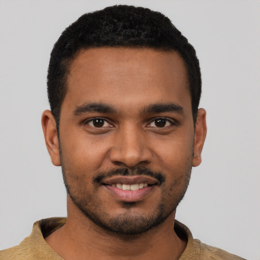 Joyful black young-adult male with short  black hair and brown eyes
