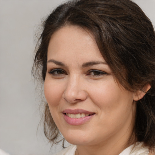 Joyful white adult female with medium  brown hair and brown eyes