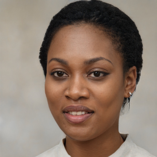 Joyful black young-adult female with short  black hair and brown eyes