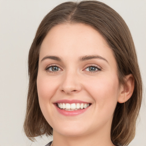 Joyful white young-adult female with medium  brown hair and green eyes