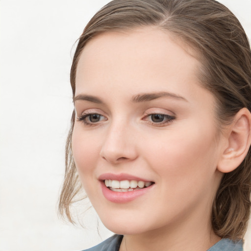 Joyful white young-adult female with long  brown hair and blue eyes