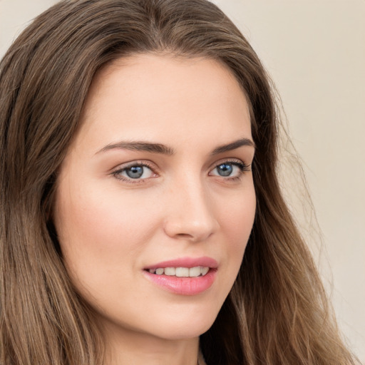 Joyful white young-adult female with long  brown hair and green eyes