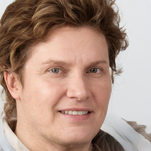 Joyful white adult male with medium  brown hair and grey eyes