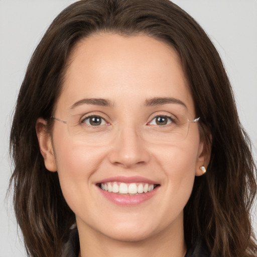 Joyful white young-adult female with long  brown hair and brown eyes