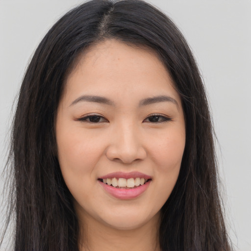 Joyful asian young-adult female with long  brown hair and brown eyes