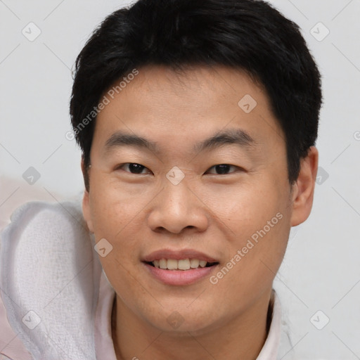 Joyful asian young-adult male with short  brown hair and brown eyes