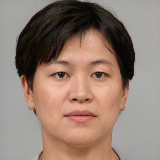 Joyful asian adult female with short  brown hair and brown eyes