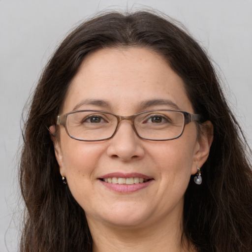 Joyful white adult female with long  brown hair and grey eyes