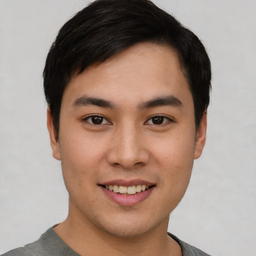 Joyful asian young-adult male with short  black hair and brown eyes