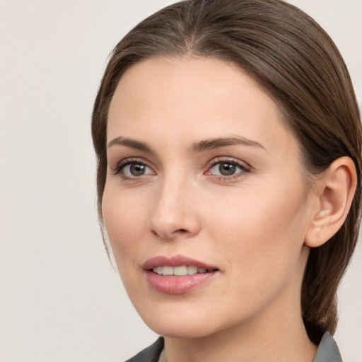 Joyful white young-adult female with medium  brown hair and grey eyes