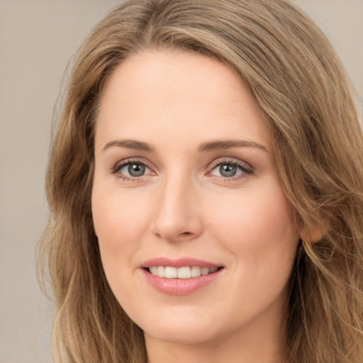 Joyful white young-adult female with long  brown hair and green eyes