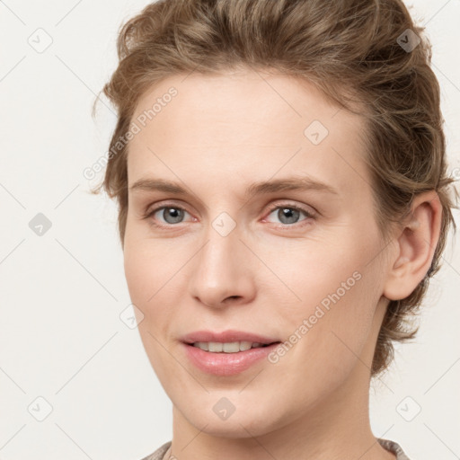 Joyful white young-adult female with medium  brown hair and grey eyes