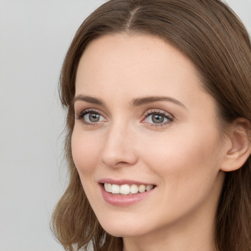 Joyful white young-adult female with long  brown hair and grey eyes